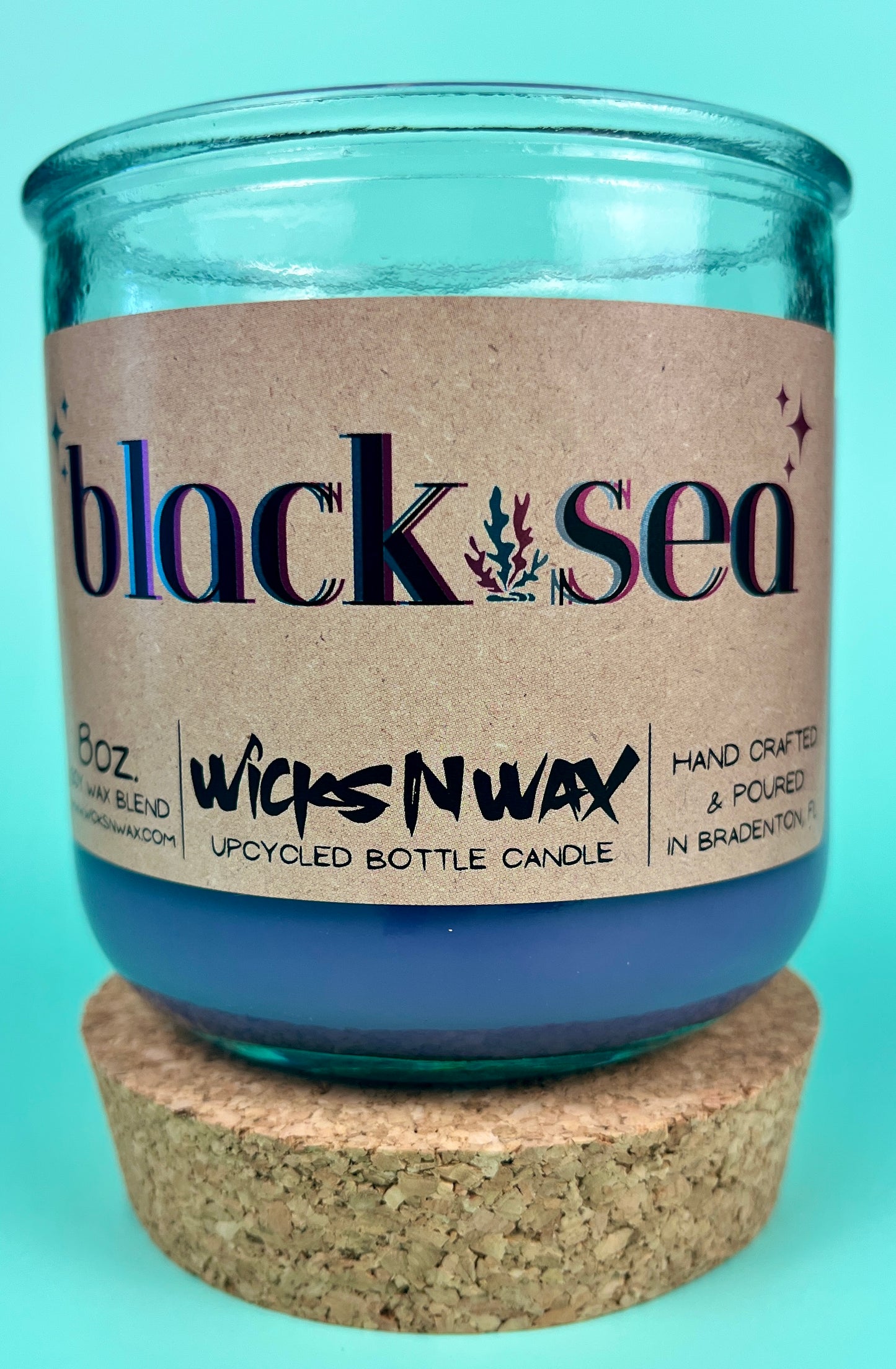 Recycled glass candle in blue jar; cork lid on bottom, label visible
