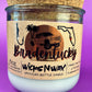 Recycled glass candle with clear jar, white wax, beige label, and natural cork lid.