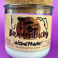 Recycled glass candle in clear jar with white wax and beige printed label, cork base.