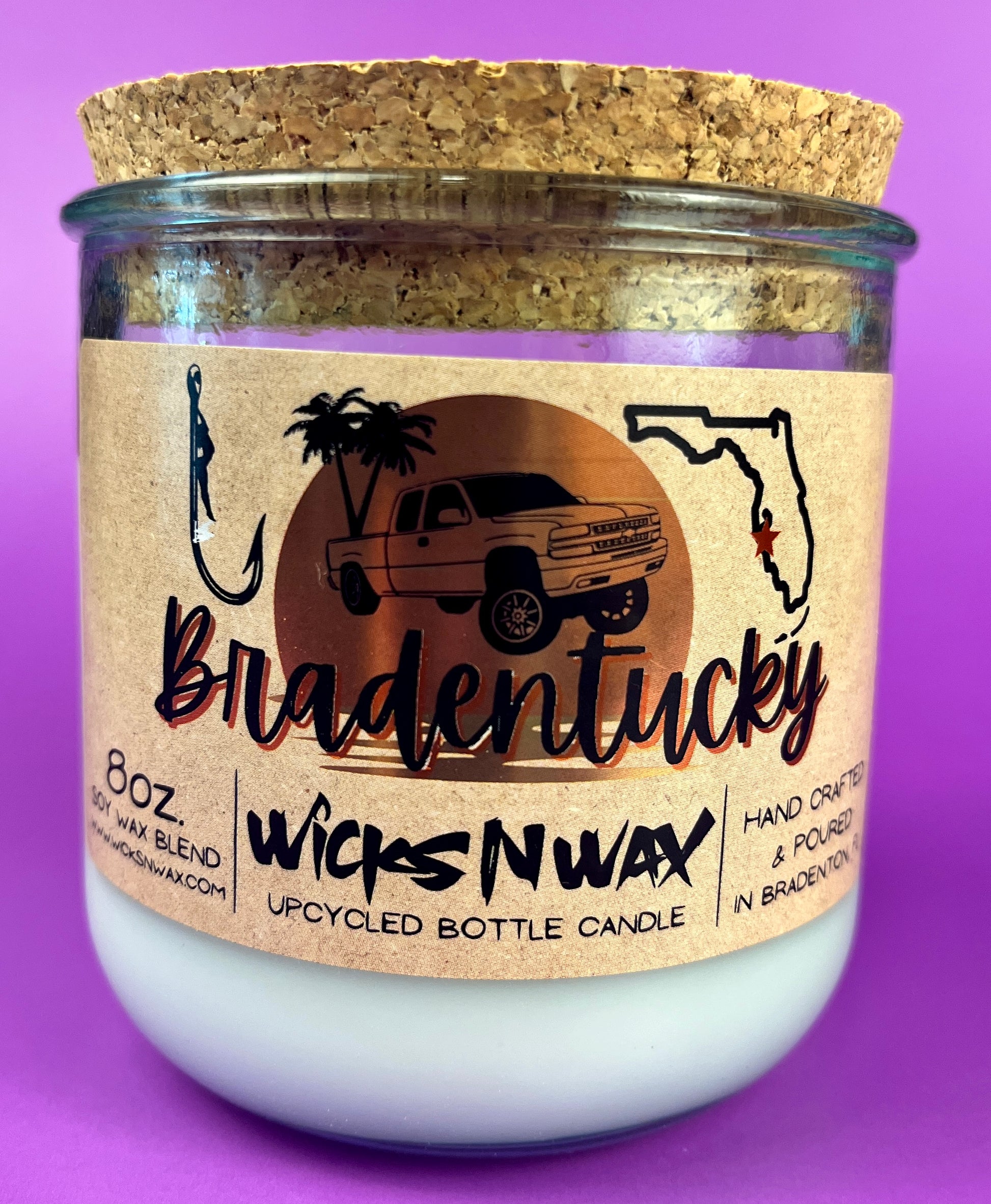 Recycled glass candle in clear jar with white wax and beige printed label, cork base.