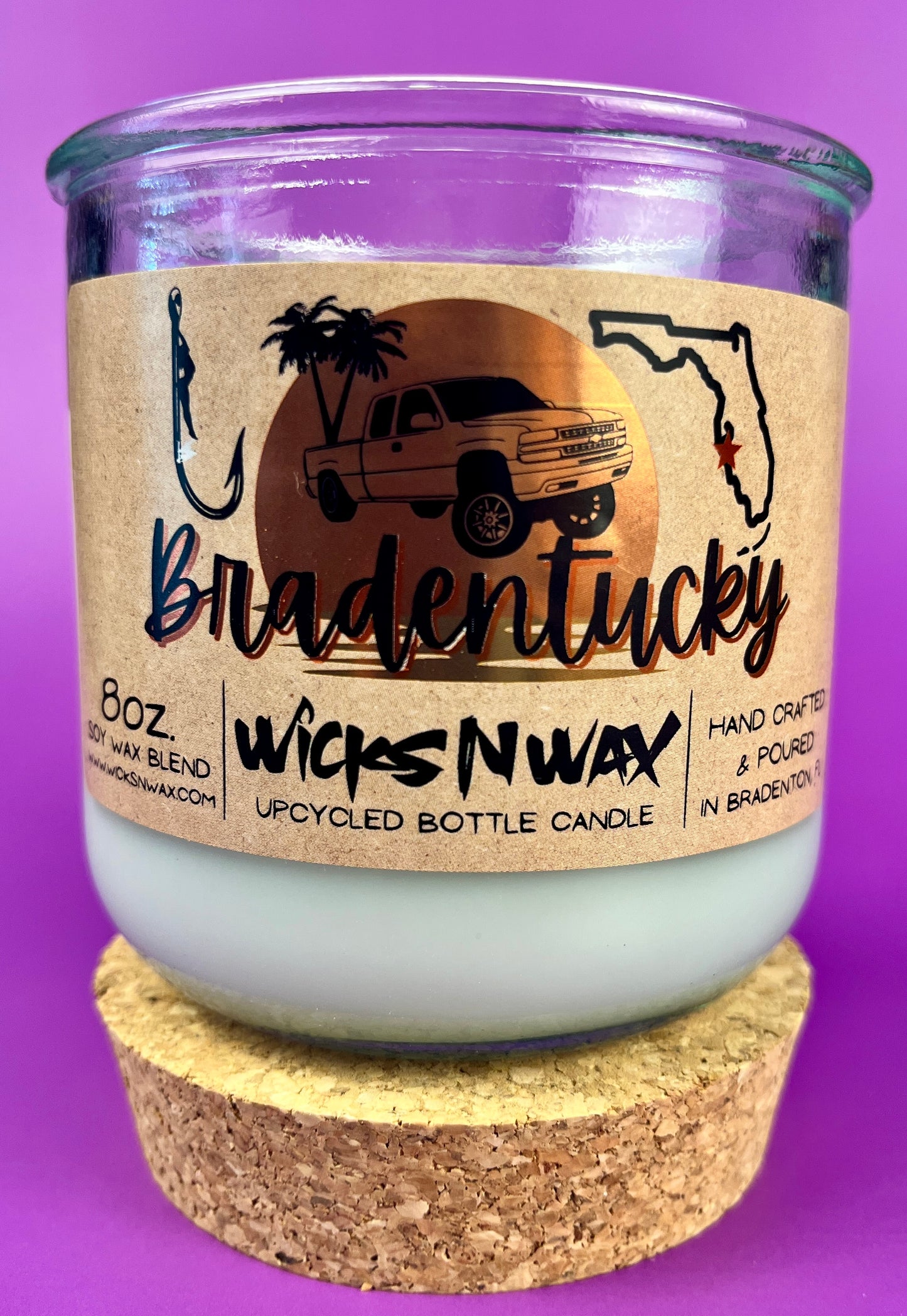 Recycled glass candle in clear jar with white wax and beige printed label, cork base.