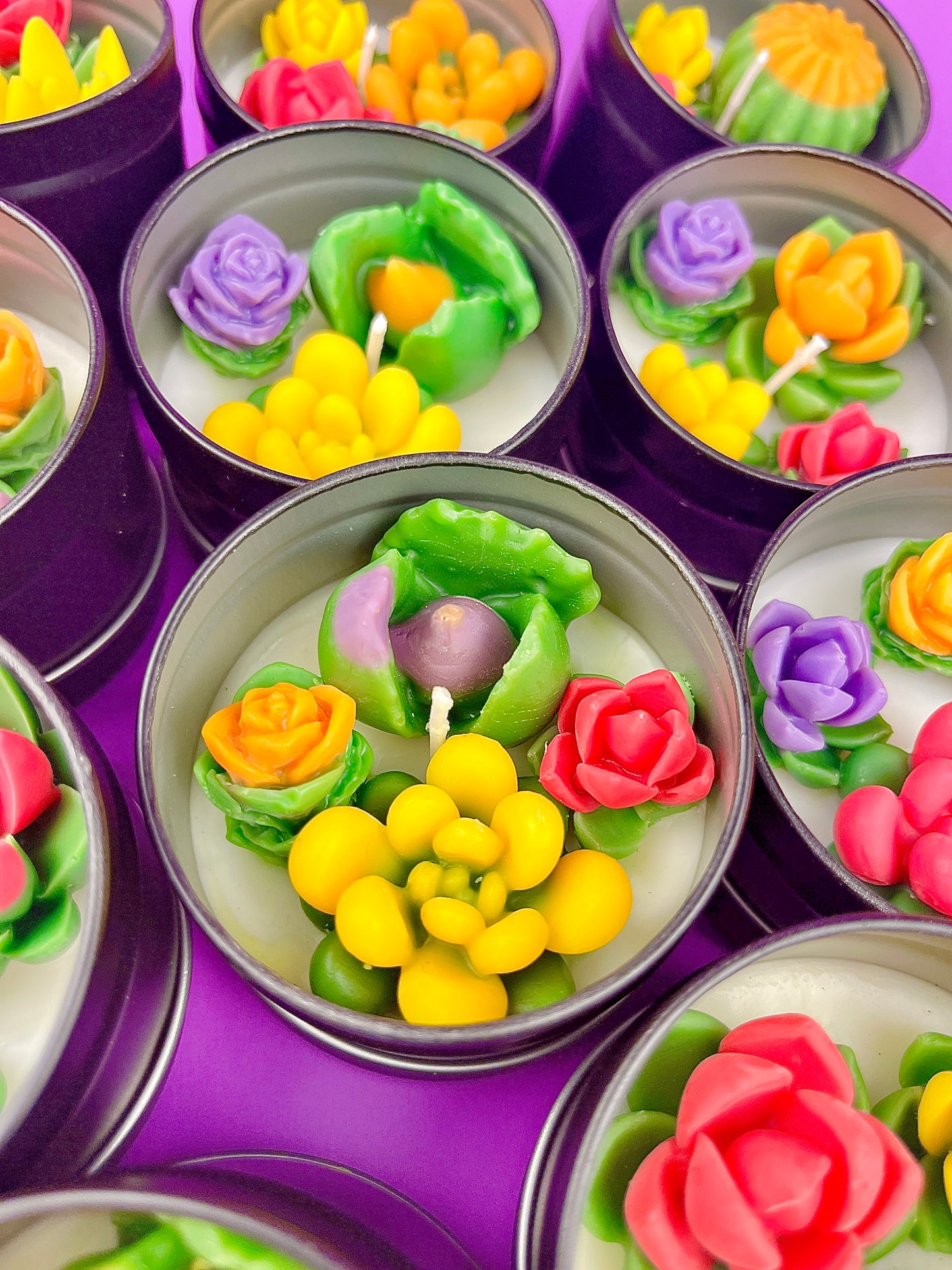Small candle tin set with green, yellow, purple, and orange flower wax pieces