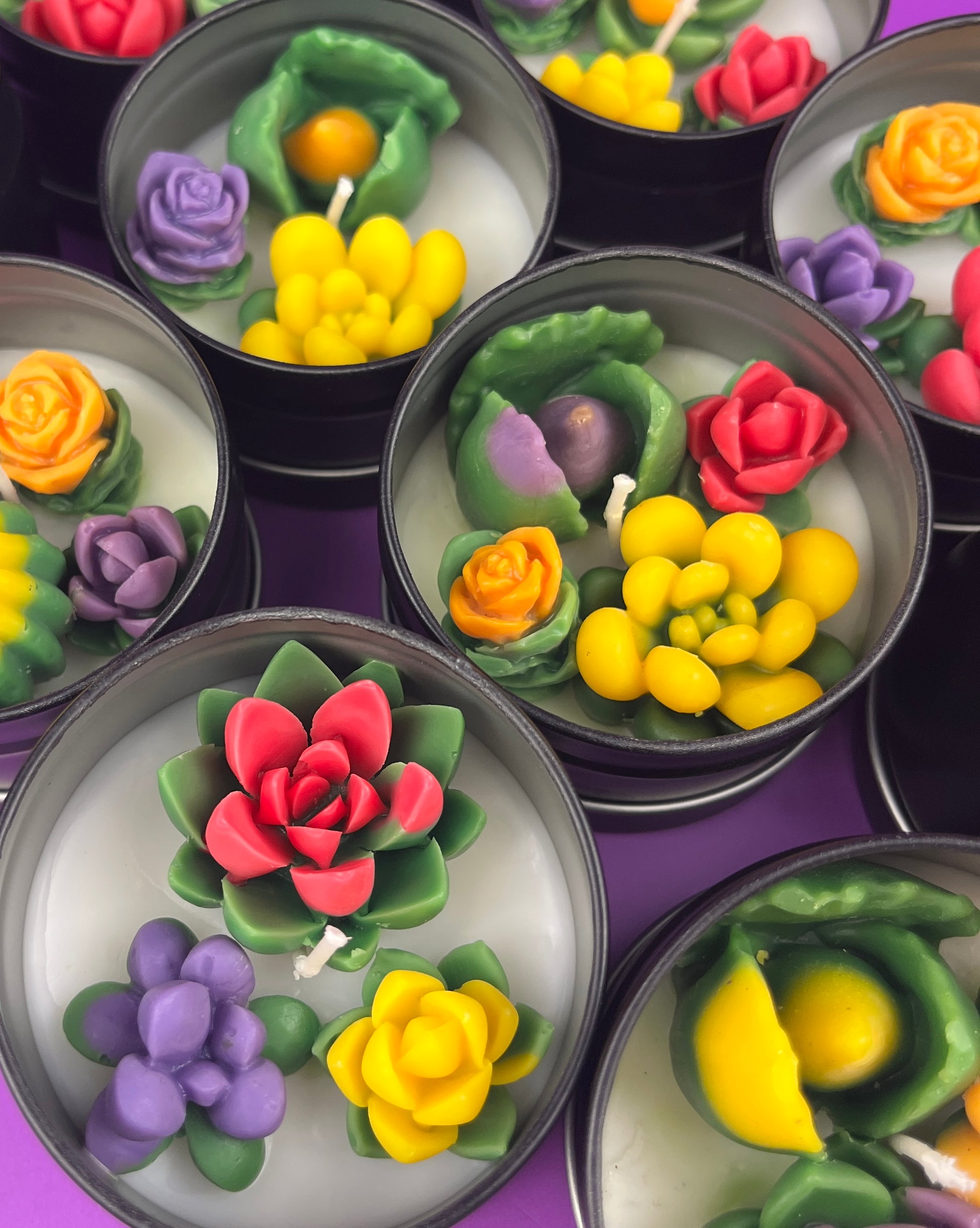 Small candle tin with red rose, green leaves, yellow buds, and purple flower wax