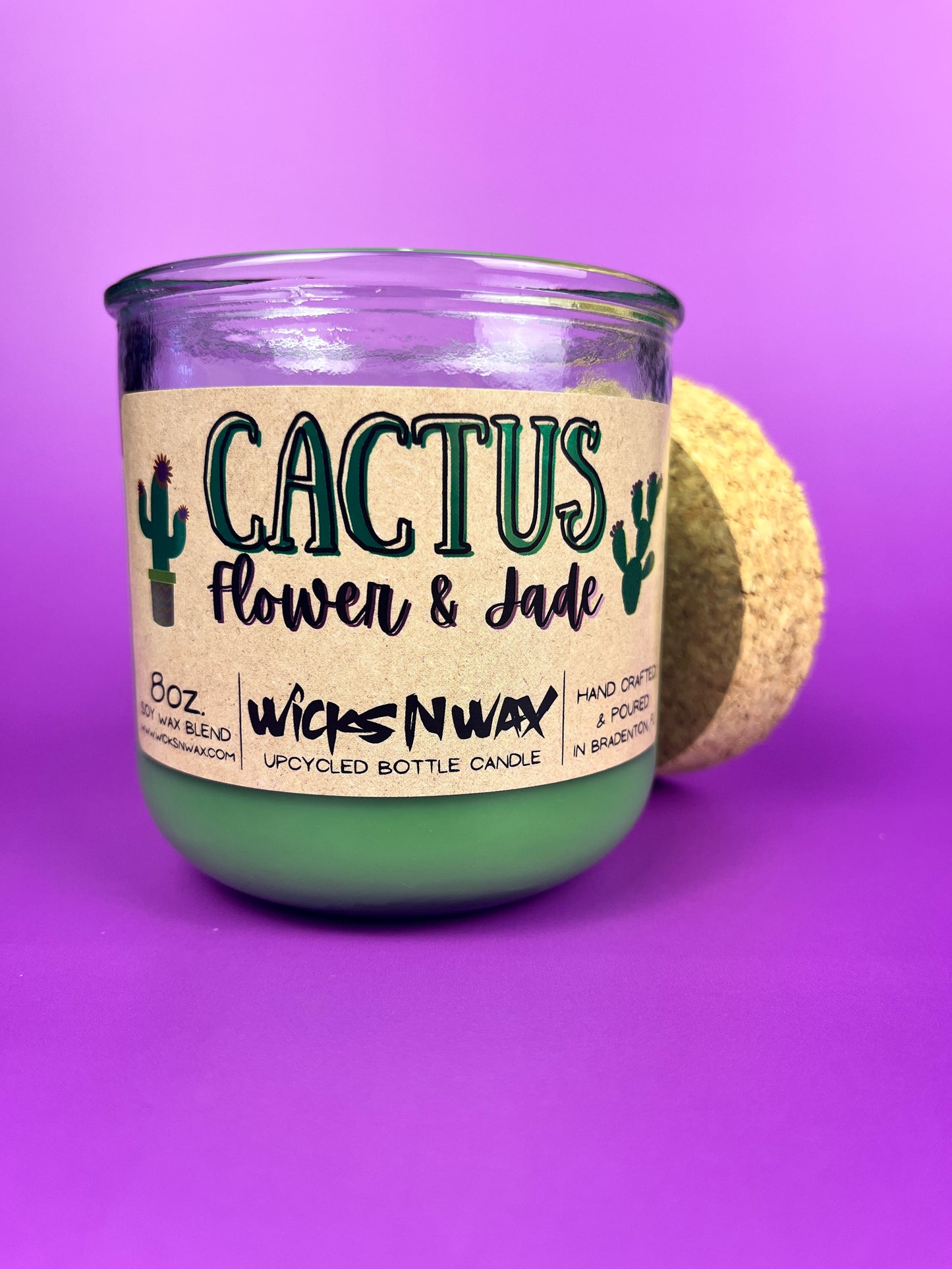 Recycled glass candle jar with printed cactus-style label, green wax, tan cork lid