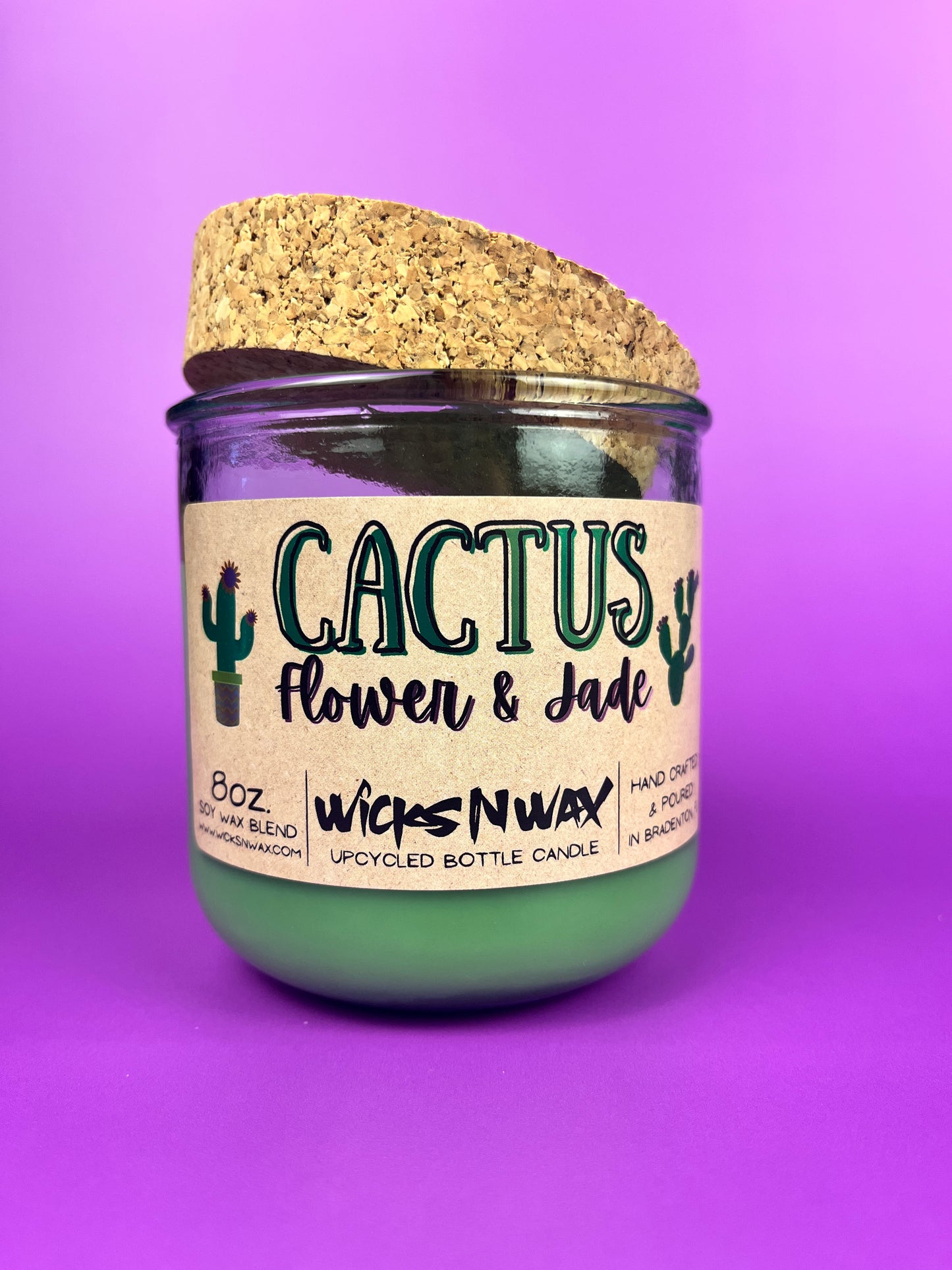 Recycled glass candle jar with printed label, green wax, and tan cork lid