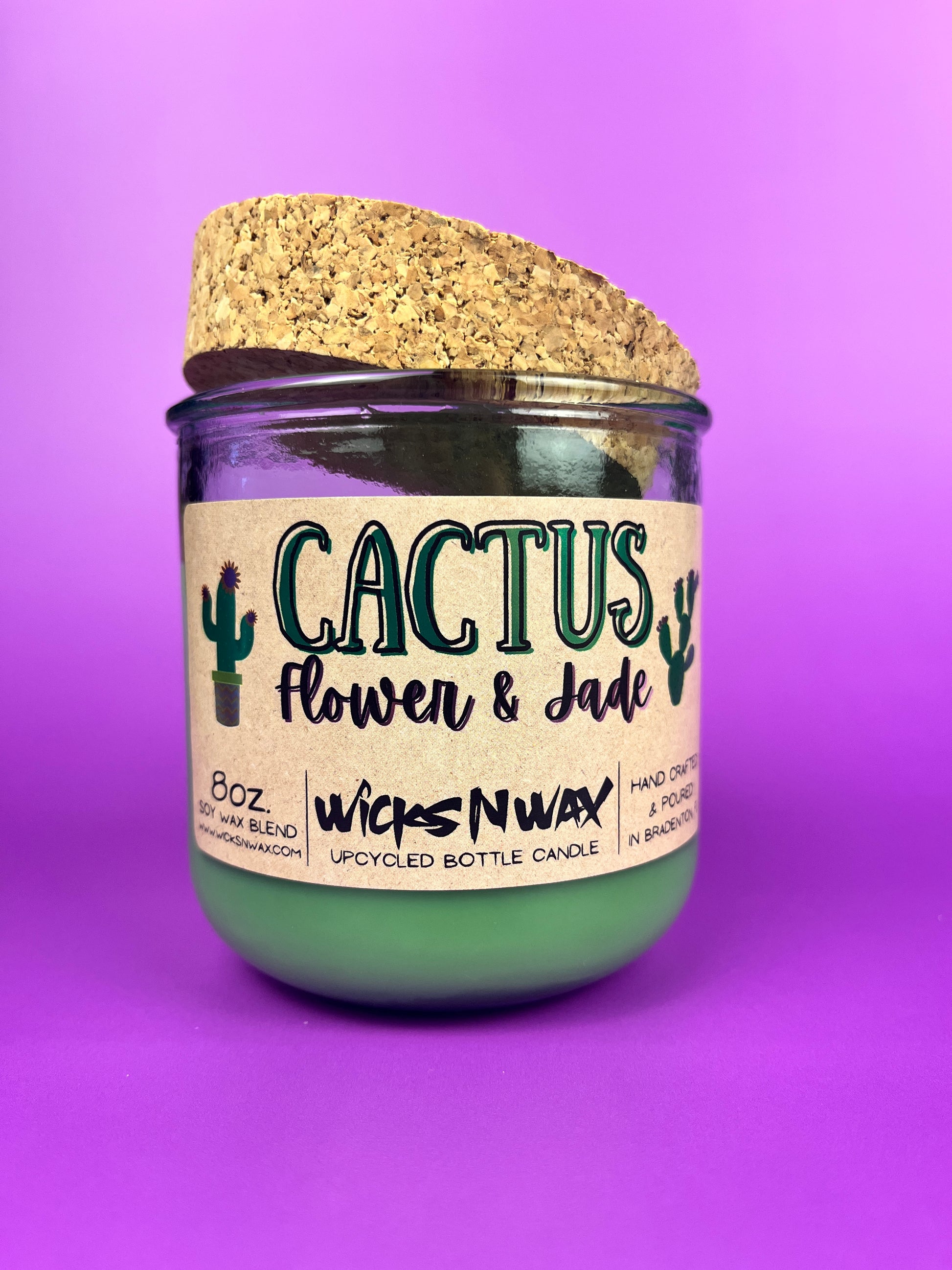 Recycled glass candle jar with printed label, green wax, and tan cork lid