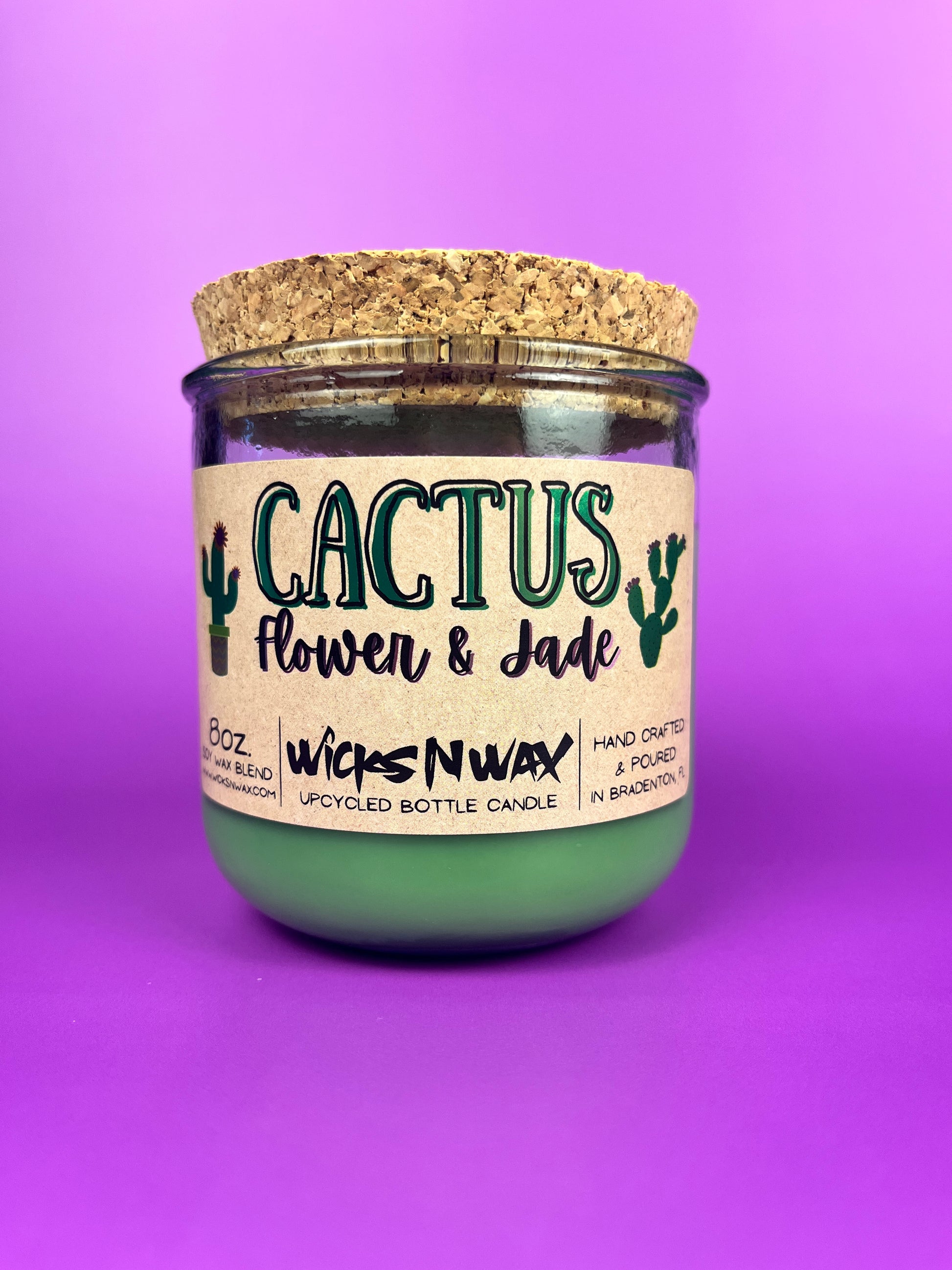 Recycled glass candle jar with printed label, green wax, and tan cork lid