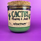 Recycled glass candle jar with printed label, green wax base, and tan cork lid