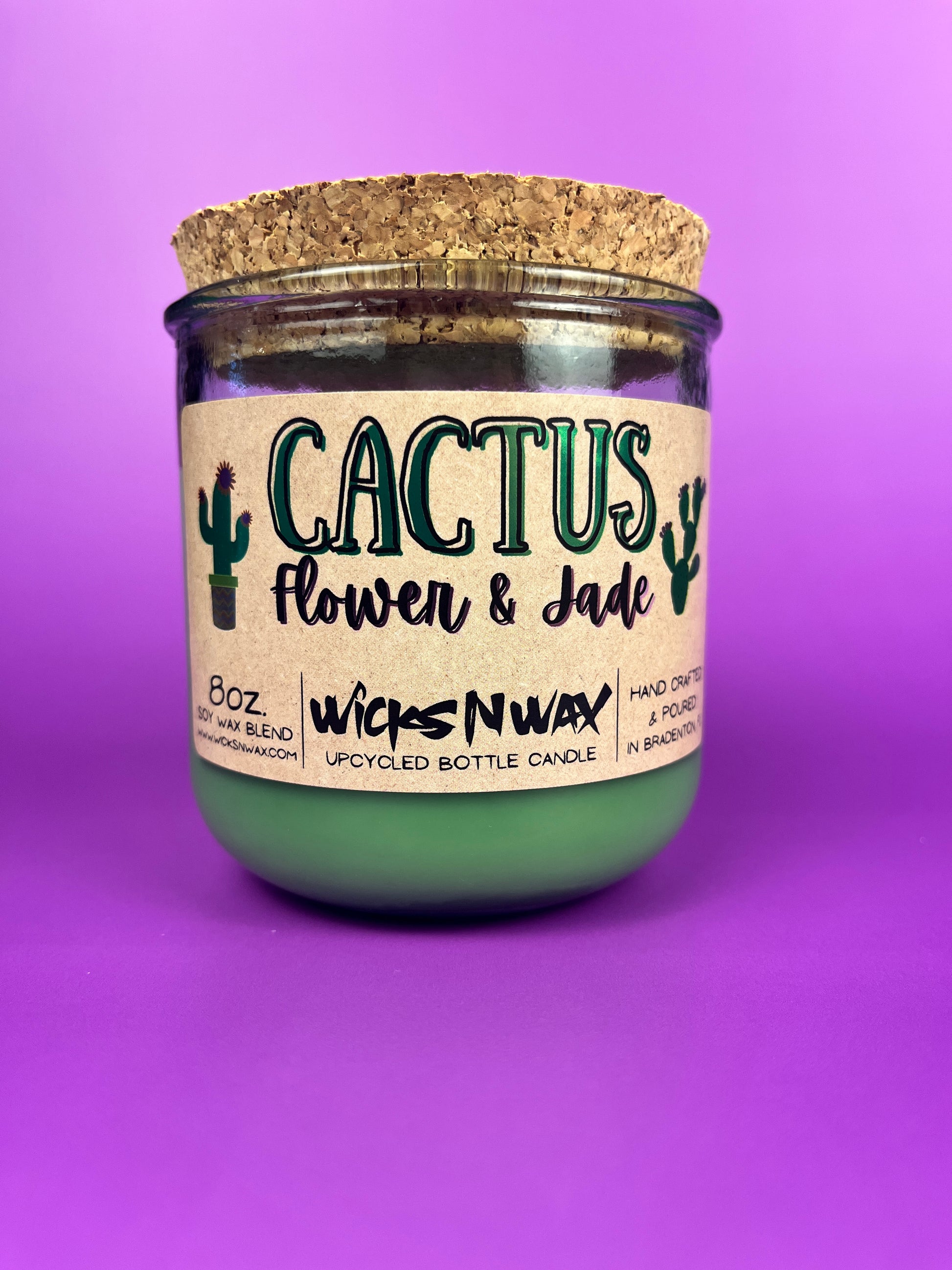 Recycled glass candle jar with printed label, green wax base, and tan cork lid