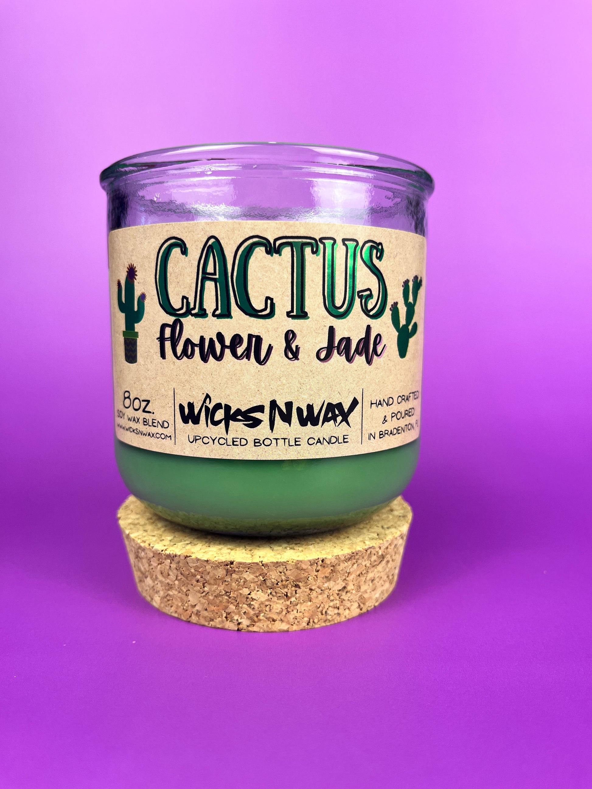 Recycled glass candle jar with printed label, green wax, and tan cork base