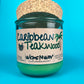 Recycled glass candle with green wax, speckled cork lid, Caribbean Teakwood label, WicksNWax