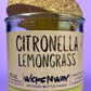 Recycled glass candle with green wax and “Citronella Lemongrass” label on jar