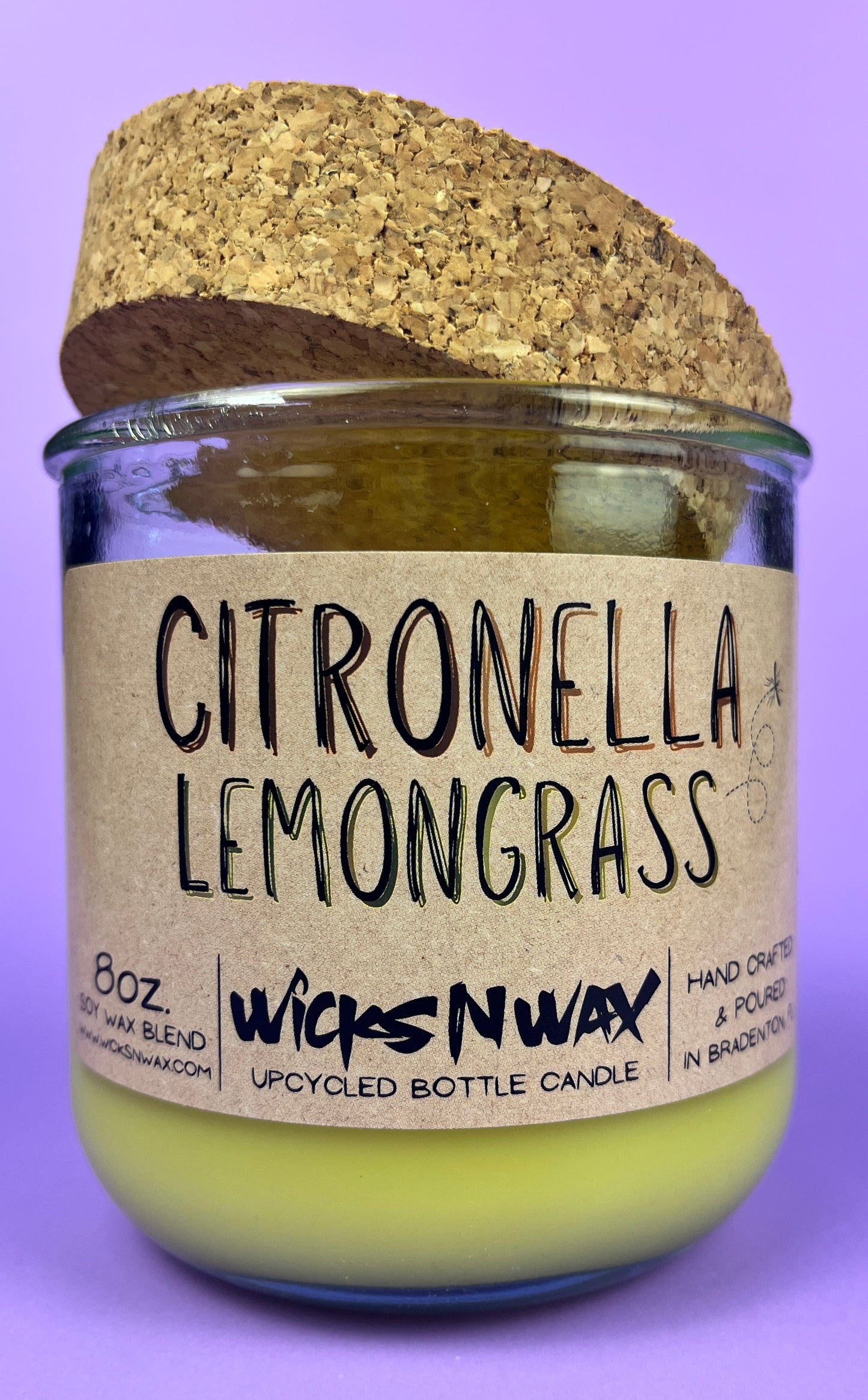 Recycled glass candle with green wax and “Citronella Lemongrass” label on jar