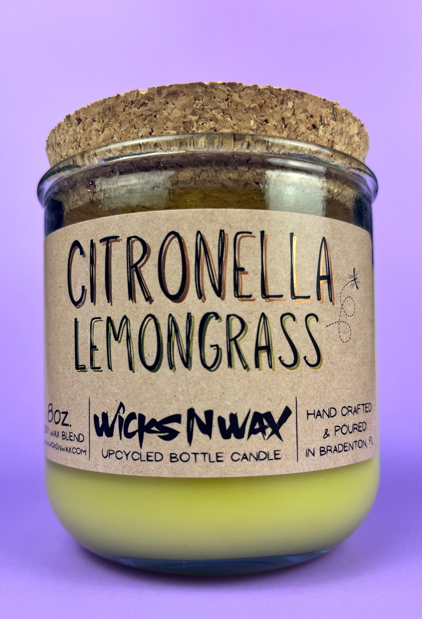 Recycled glass candle with green wax and “Citronella Lemongrass” label and cork lid