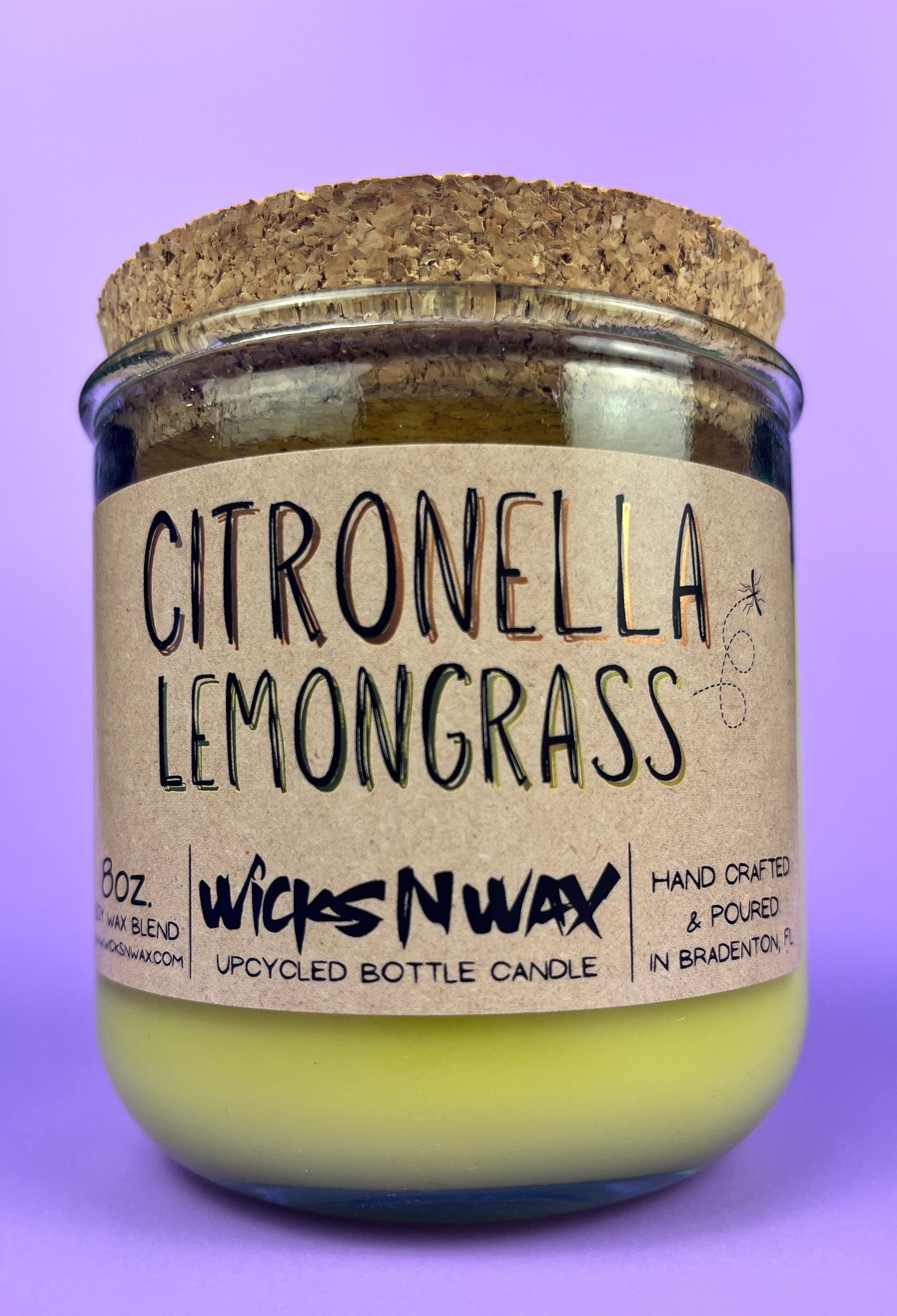 Recycled glass candle with green wax and “Citronella Lemongrass” label and cork lid