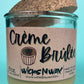 Recycled glass candle with kraft label and creamy wax; cork lid visible