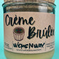 Recycled glass candle with kraft label and creamy wax; cork top visible