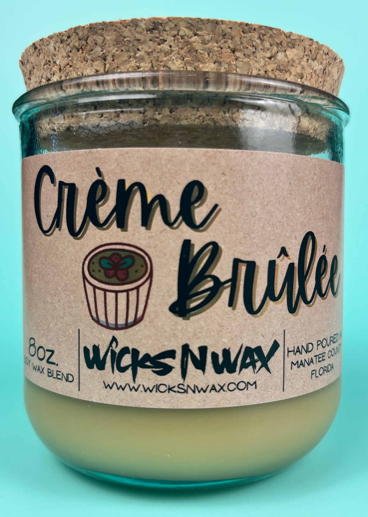 Recycled glass candle with kraft label and creamy wax; cork top visible