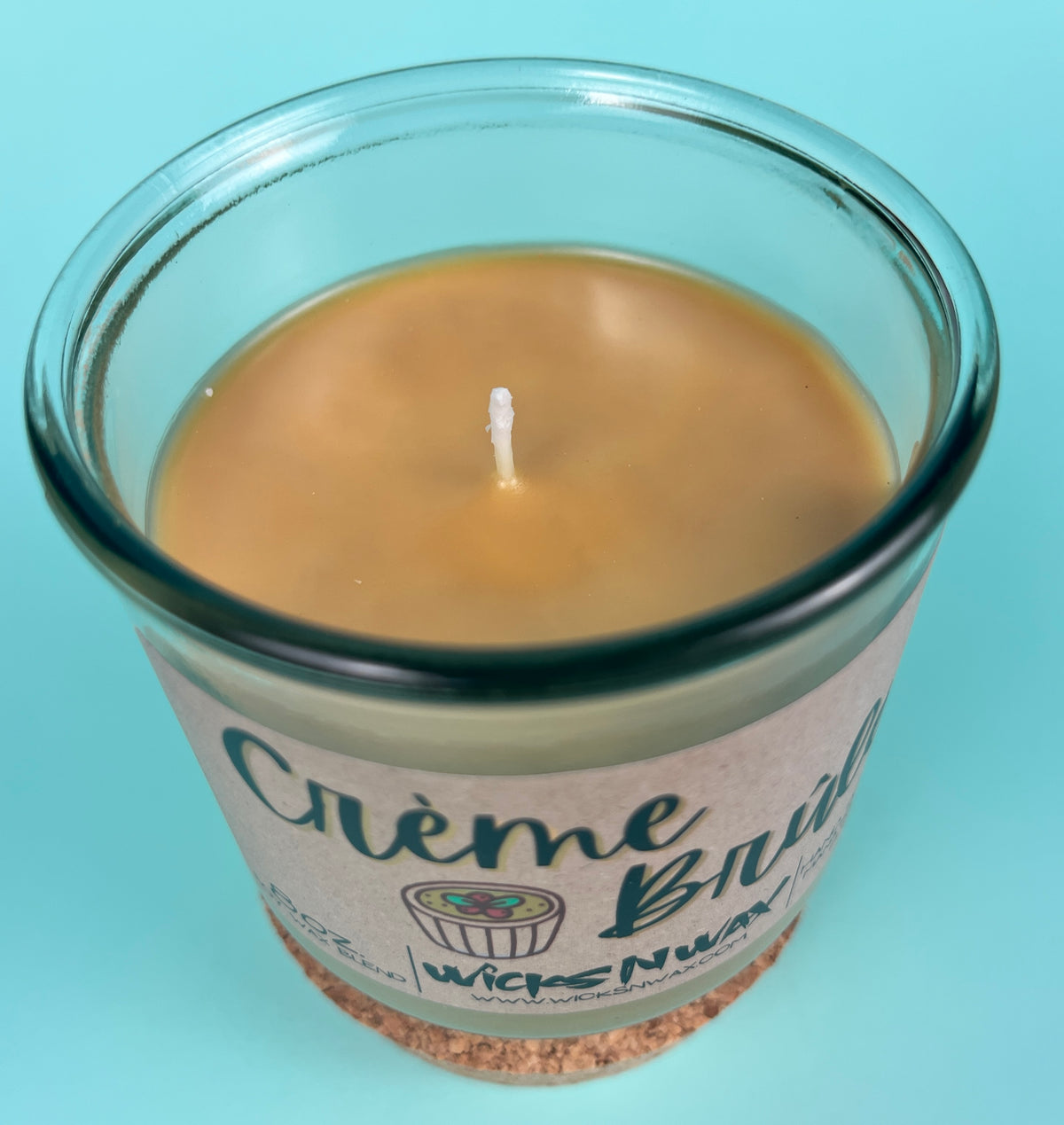 Recycled glass candle with creamy wax and wick centered inside the jar