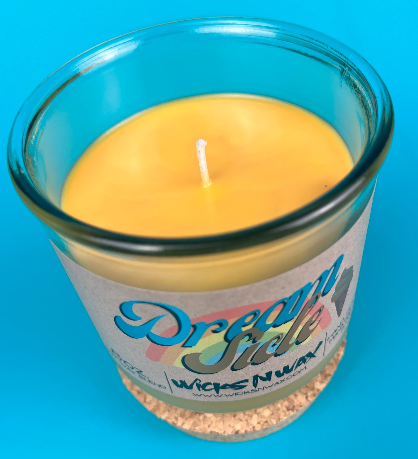 Recycled glass candle jar with cork base, yellow wax pool and centered wick