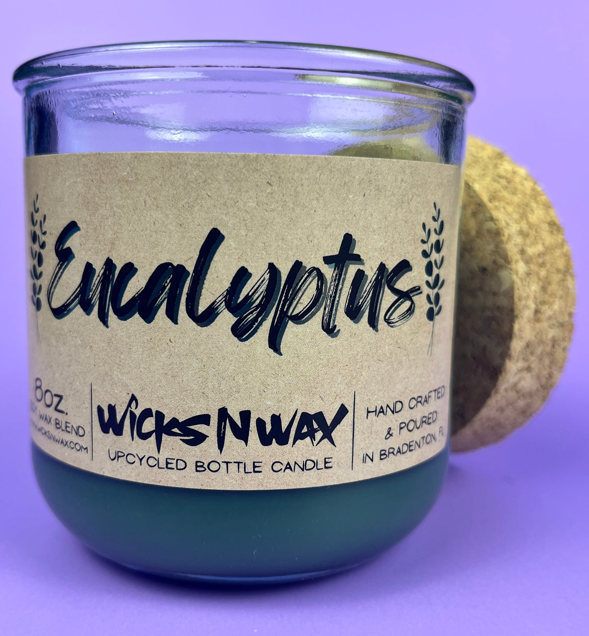 Eucalyptus recycled glass candle close-up, dark green wax in clear jar and cork lid