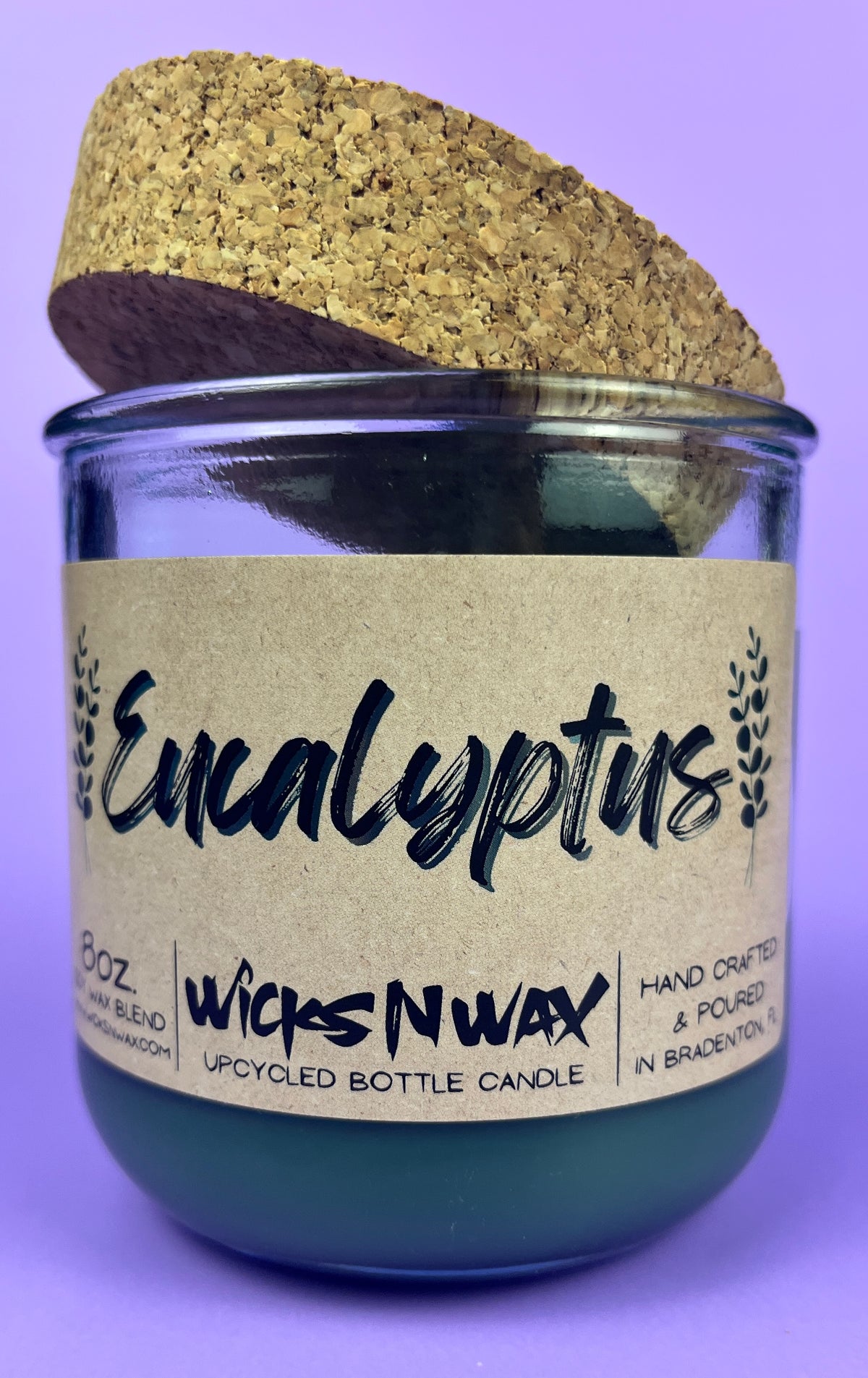 Eucalyptus recycled glass candle with cork lid; WicksNWax label on dark green glass