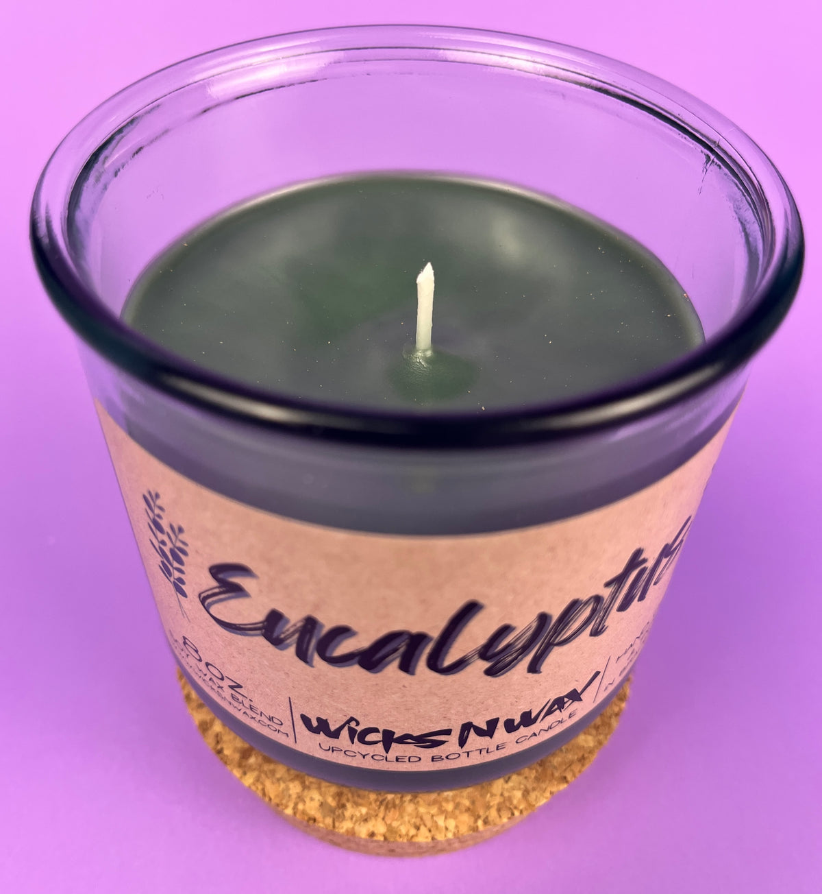 Eucalyptus recycled glass candle with wick visible; WicksNWax label; dark green glass