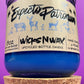 Blue glass candle jar with cream label and illustrated figures, cork base included