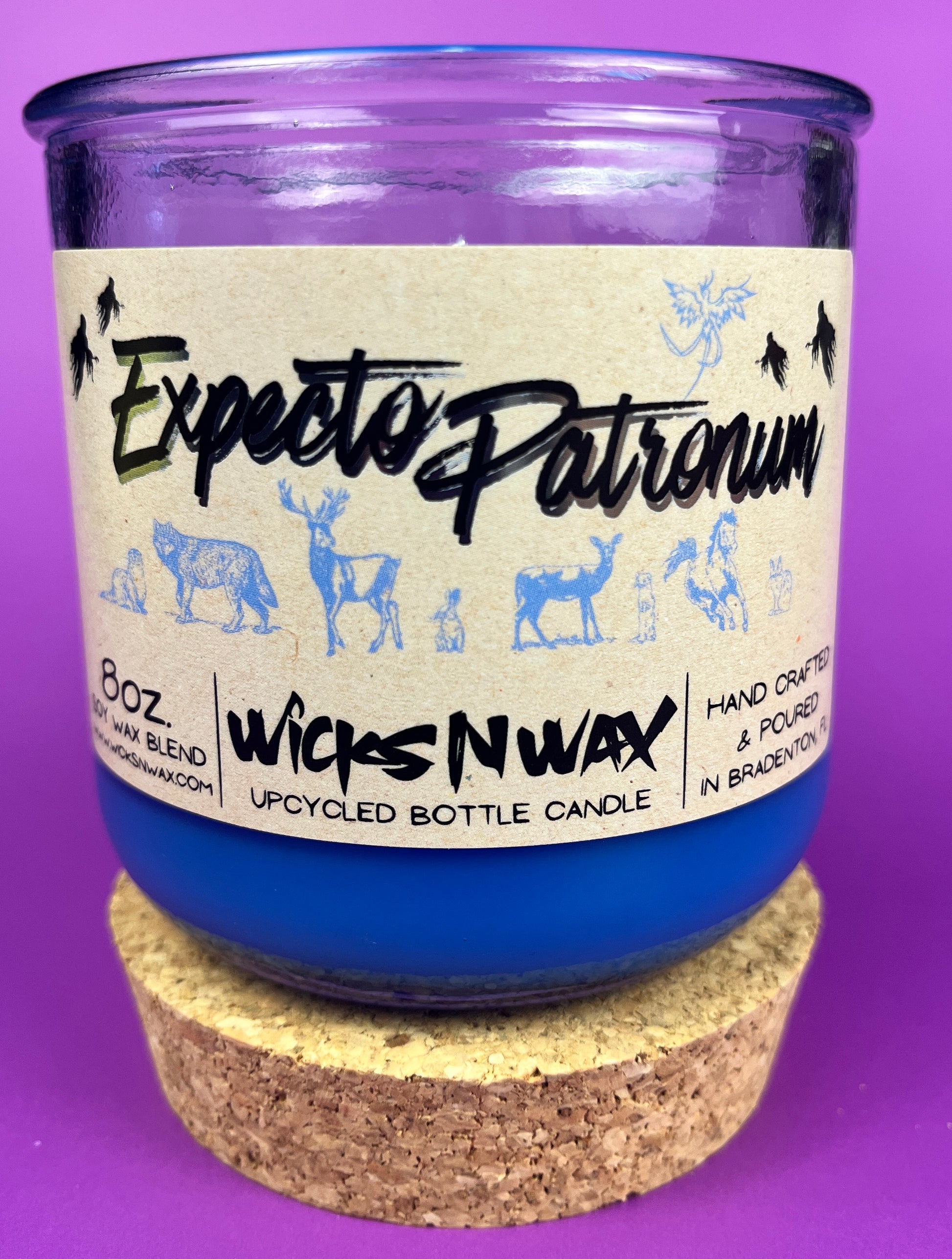 Blue glass candle jar on cork base with cream label and illustrated animal silhouettes
