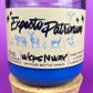 Blue glass candle jar with cream label and illustrated figures, cork base ring shown
