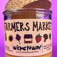Glass candle jar with Farmers Market label and cork lid, amber wax surface visible