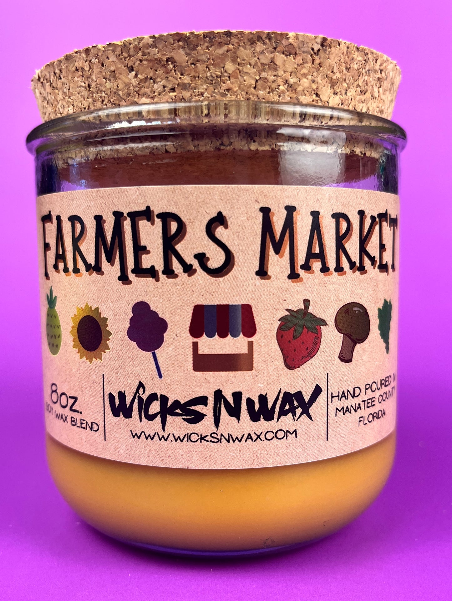 Glass candle jar with Farmers Market label and cork lid, amber wax fill visible