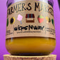 Glass candle jar with Farmers Market label, amber wax pool and cork base visible