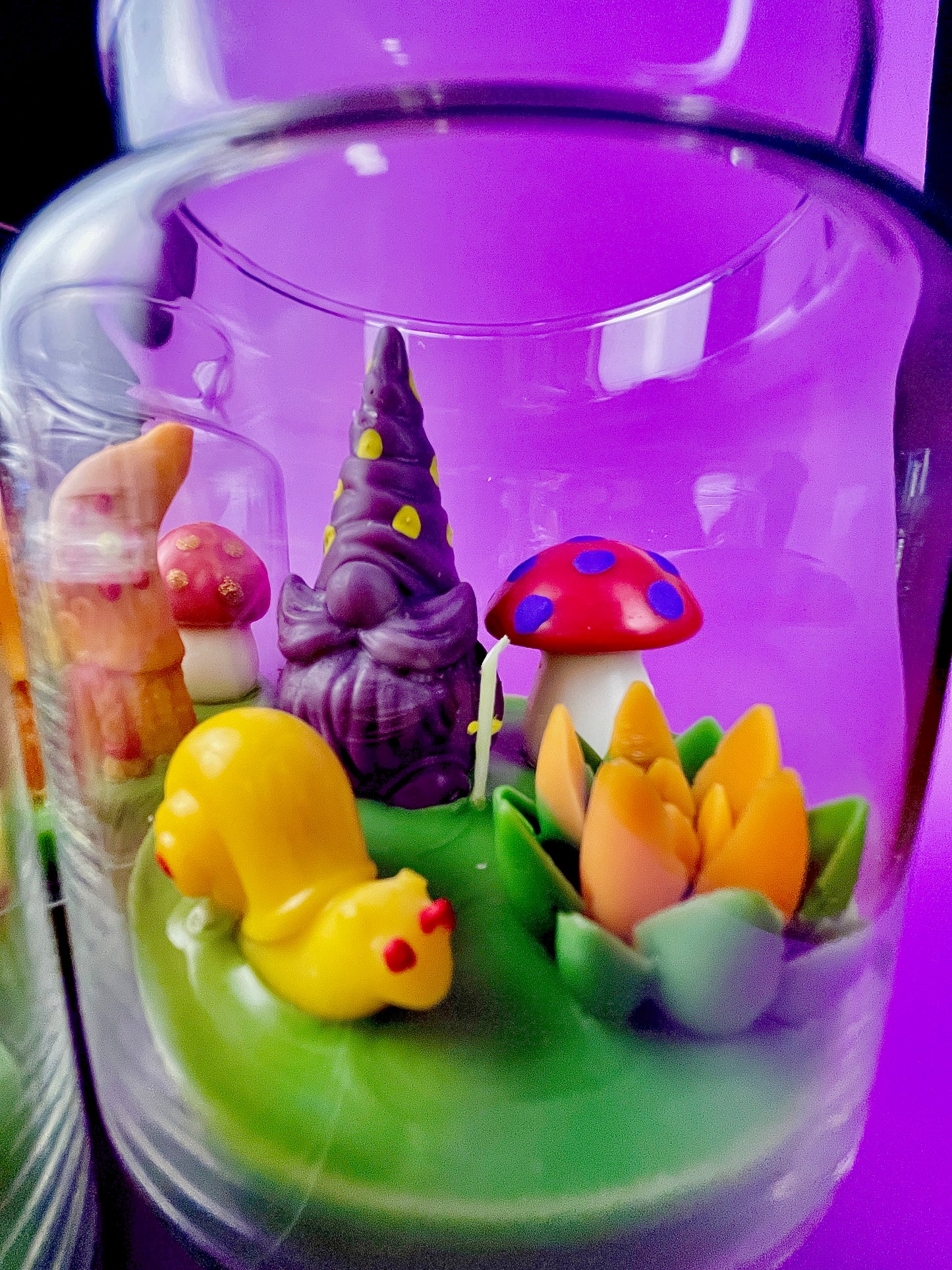 Garden gnome art candle in clear glass jar with green wax and mushroom and gnome figures