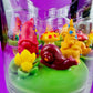 Garden gnome art candle jar with green wax base and red gnome, yellow cone, and purple accents