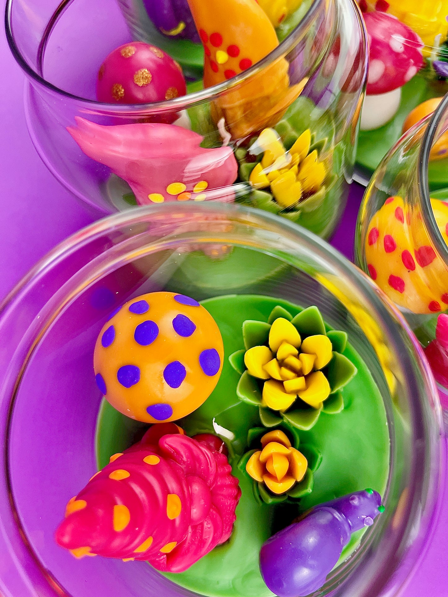Garden gnome art candle jar with green wax base and purple, pink, and yellow wax flowers