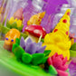 Garden gnome candle: yellow gnome, orange mushroom and purple and pink flowers