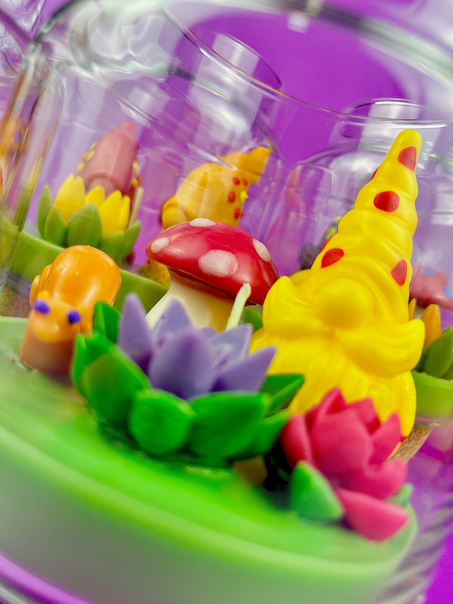 Garden gnome candle: yellow gnome, orange mushroom and purple and pink flowers
