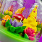 Garden gnome candle: yellow gnome, red mushroom and pink flowers on green wax