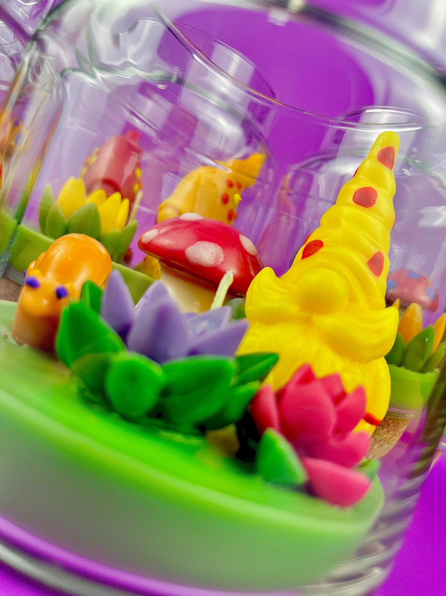 Garden gnome candle: yellow gnome, red mushroom and pink flowers on green wax