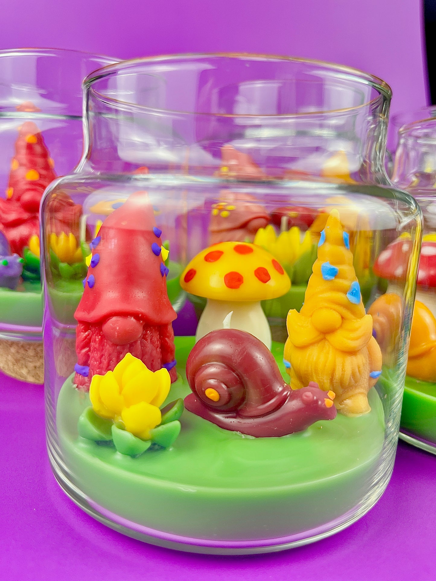 Garden gnome candle: red gnome, yellow figures, snail and green wax base