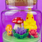 Garden gnome art candle in clear glass jar with green wax and yellow gnome and flowers