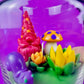 Garden gnome art candle in clear glass jar with green wax and flower figurines