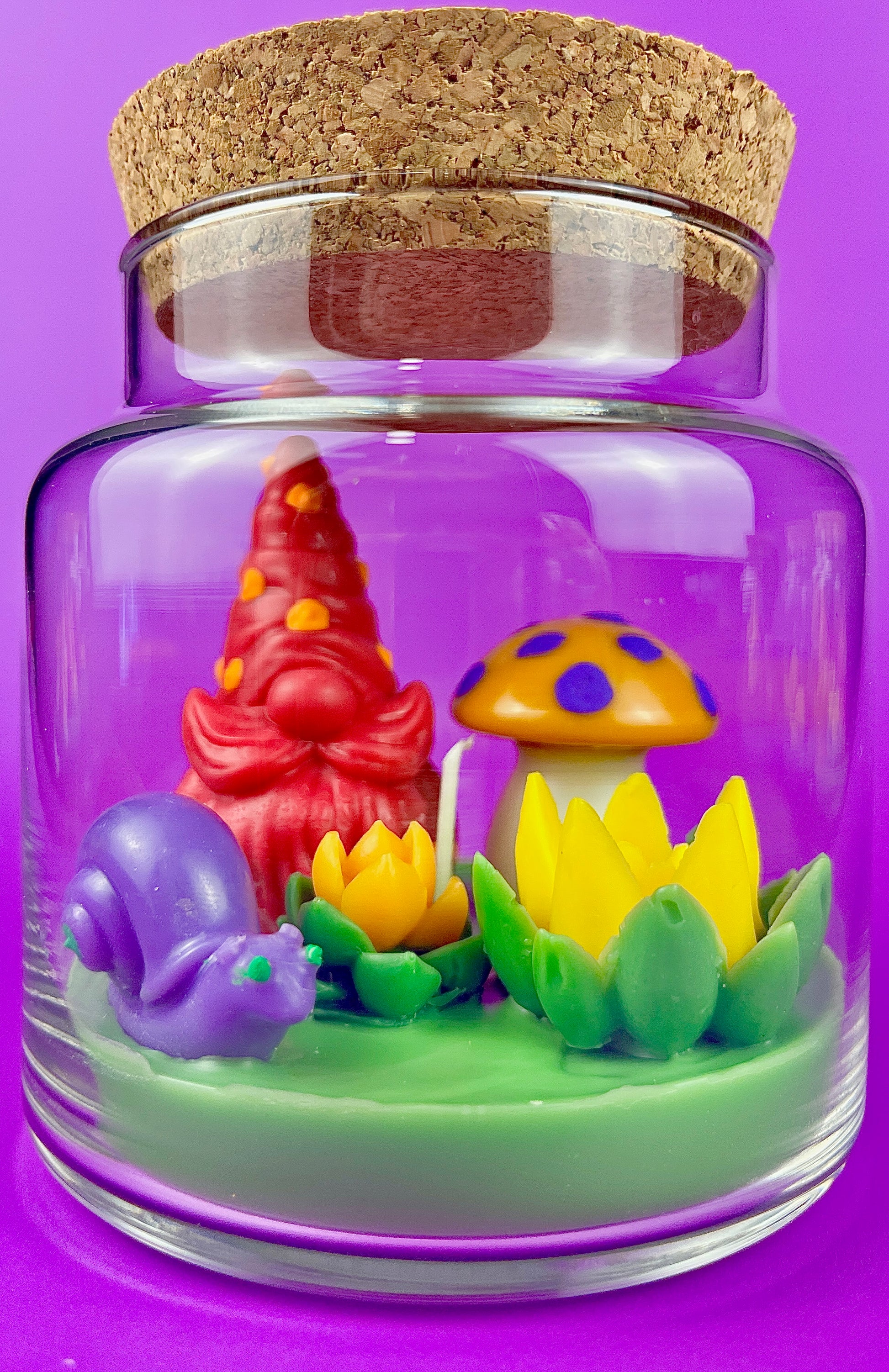 Garden gnome art candle jar with green wax base, colorful mushrooms, and purple gnome