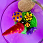 Garden gnome art candle in clear jar with green wax and colorful mushroom and gnome toppers