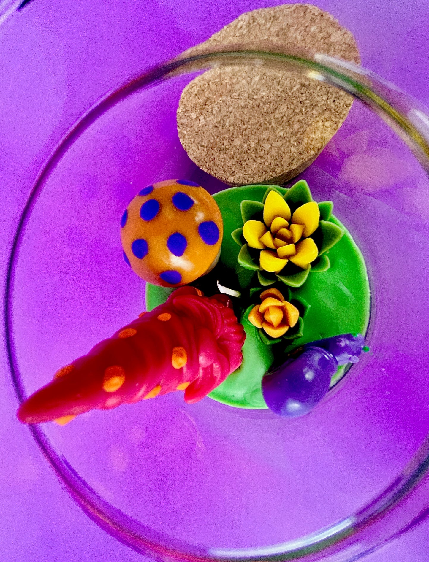 Garden gnome art candle in clear jar with green wax and colorful mushroom and gnome toppers