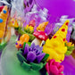 Garden gnome art candle in clear glass jar with green wax and yellow gnome and purple flower shapes
