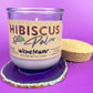 Recycled glass candle in purple jar on cork base with Hibiscus label and wick