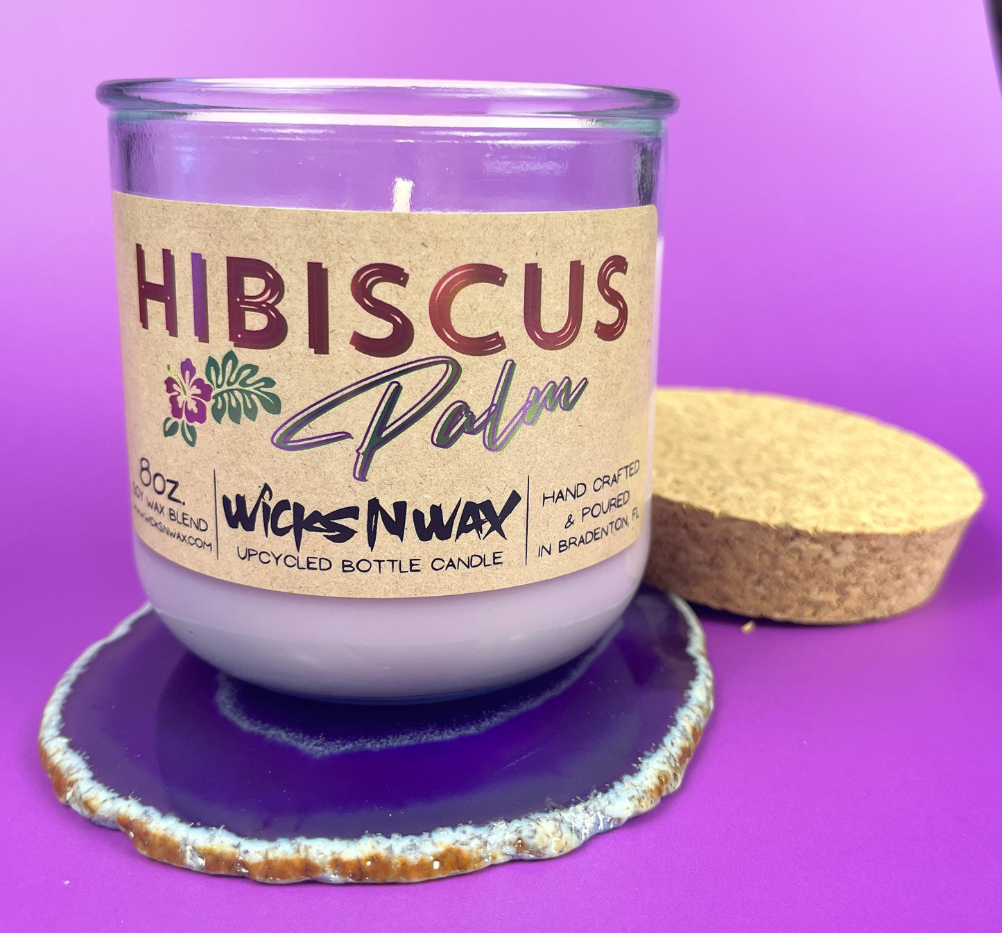 Recycled glass candle in purple jar on cork base with Hibiscus label and wick