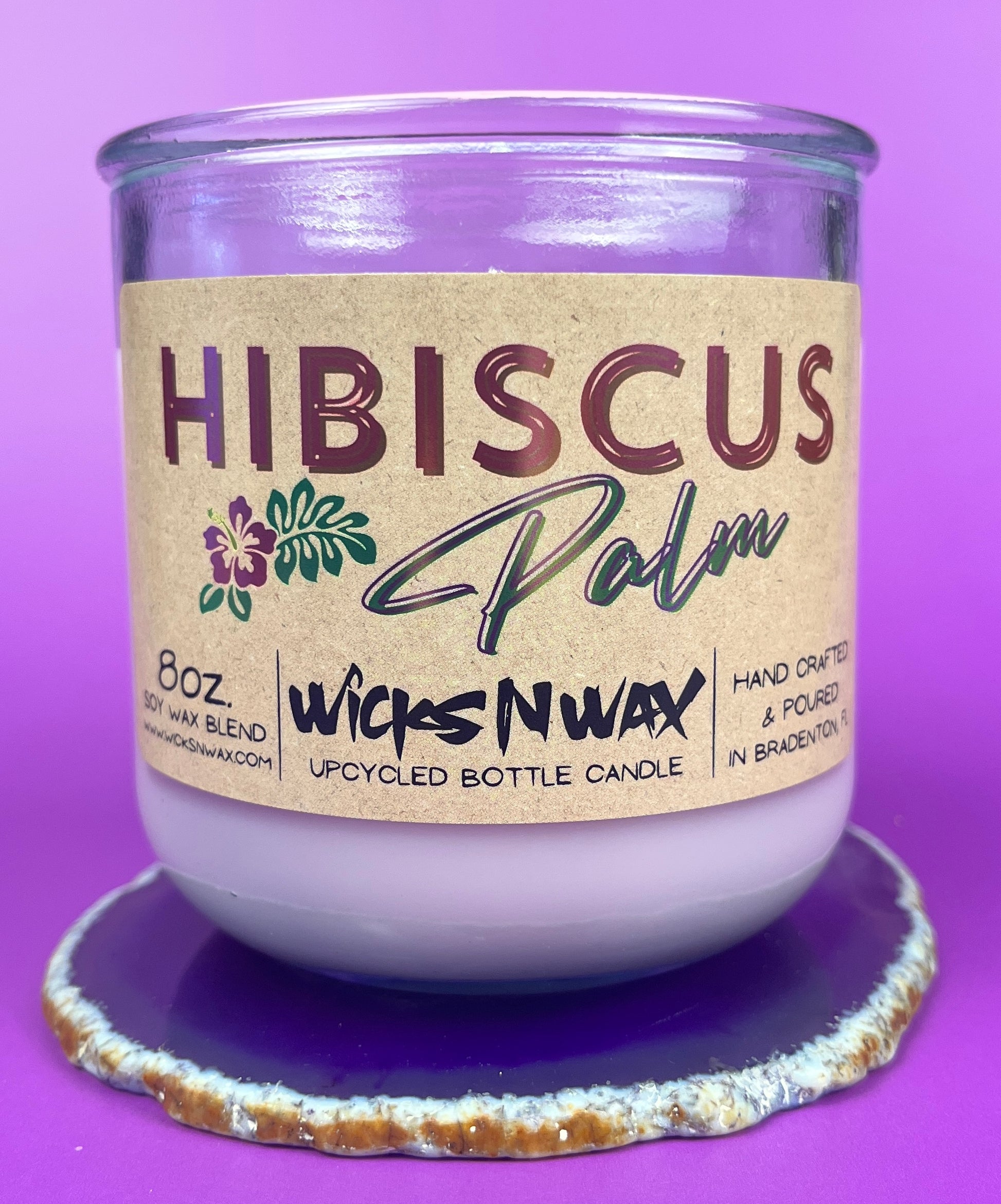 Recycled glass candle in purple jar on cork base with Hibiscus label